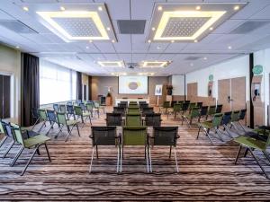 a conference room with chairs and tables and a podium at Novotel Rotterdam - Schiedam in Schiedam +157 photos