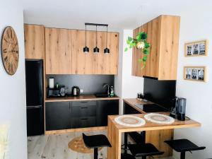 a kitchen with wooden cabinets and a table and chairs at Apartament Amelia in Zamość