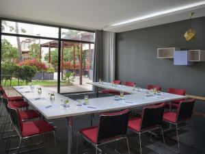 a conference room with a long table and red chairs at Novotel Dakar in Dakar +78 photos