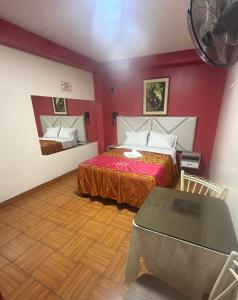 a bedroom with two beds and a table in it at hotel dominicos & parkas in Lima