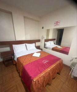 a hotel room with two beds and a table at hotel dominicos & parkas in Lima