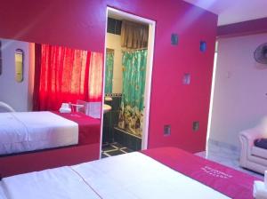 a hotel room with two beds and red walls at hotel dominicos & parkas in Lima