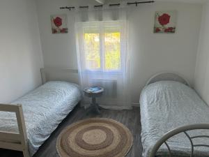 two twin beds in a room with a window at Family House in Beauvais