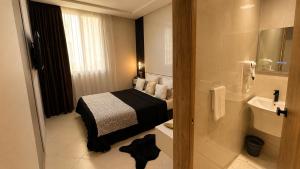 a bedroom with a bed and a bathroom with a shower at Hotel Vents Des Iles in Essaouira +44 photos