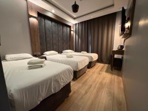 a hotel room with three beds and a table at The Basilissis Gulhane in Istanbul