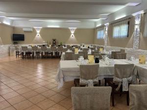 a banquet hall with tables and chairs with white tablecloths at Masseria La Guardata in Guglionesi