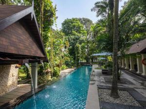 a swimming pool in a resort with trees at Novotel Bogor Golf Resort & Convention Center in Bogor