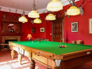 a pool table in a room with red walls at Derry - Mar Lodge Estate in Ballater