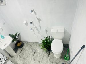 a white bathroom with a toilet and a sink at Moonlight Villa in Pottuvil