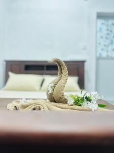 a towel with a snake on top of a bed at Moonlight Villa in Pottuvil
