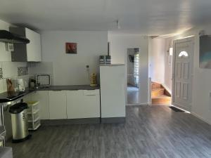 a kitchen with white cabinets and a door to a hallway at Family House in Beauvais