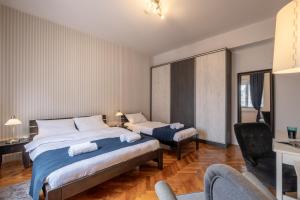 a hotel room with two beds and a chair at Selection Rooms in Belgrade