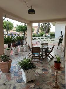 a patio with a table and chairs and potted plants at BOUGANVILLE casa vacanza ambiente climatizzato con wi fi in Pineto
