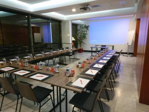 a group of tables in a room with a screen at ibis Périgueux Centre in Périgueux