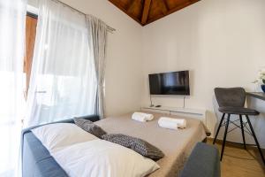 a bedroom with a bed and a tv and a chair at Holiday house "Maria" in Privlaka