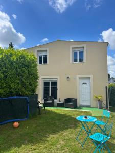 a house with chairs and a table in the yard at Family House in Beauvais
