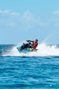 eine Person, die mit einem Jetski im Wasser fährt in der Unterkunft El Classicoo Apartment in Rubavu