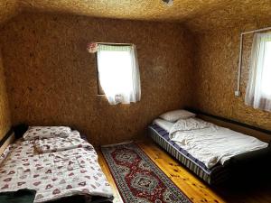 two beds in a small room with a window at Ivanovo Polje Chalet in Pljevlja
