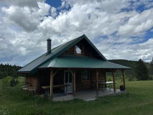 a log cabin with a picnic table in a field at Ivanovo Polje Chalet in Pljevlja +5 photos