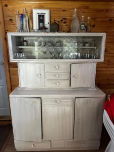 a white cabinet with dishes on top of it at Ivanovo Polje Chalet in Pljevlja