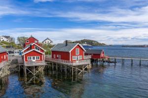 a group of houses on a dock in the water at Reine seaview cabin in Reine