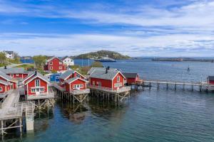 a group of houses on a dock in the water at Reine seaview cabin in Reine +54 photos