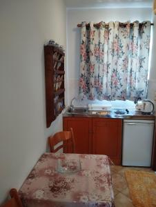 eine Küche mit Tisch, Spüle und Fenster in der Unterkunft WHITE CASTLE Studios in Lefkos Karpathos + 37 Fotos