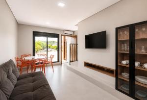 a living room with a couch and a table at Pousada Soul Papagaio - lofts completos a 30 metros do mar in Palhoça