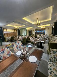 a hotel lobby with couches and tables and chairs at Hotelyashraj in Pipra Dewās