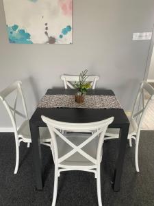 a black table with white chairs and a potted plant on it at Old Pier Apartments in Bridport +15 photos