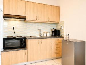 a kitchen with wooden cabinets and a stainless steel refrigerator at Tolo at sea - Emma in Tolo