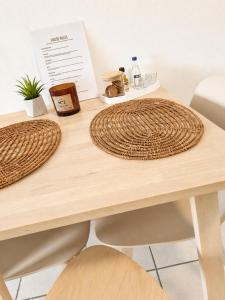 a wooden table with two large wicker mats on it at Tolo at sea - Emma in Tolo