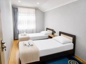 a room with two beds and a window at Chkalovka Guest House With Sevan View in Sevan