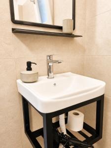 a bathroom with a white sink and a mirror at Tolo at sea - Emma in Tolo