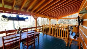 a porch of a cabin with a table and chairs at Big Timber Creek Cabin in Sugar Grove