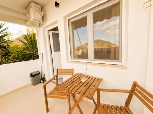 a table and two chairs on a porch with a window at Tolo at sea - Emma in Tolo +6 photos