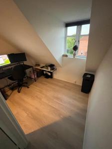 an attic room with a desk and a window at patriciervilla i 2plan udlejes in Hjørring