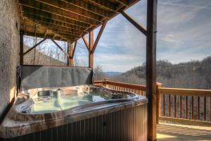 a large hot tub on a porch of a cabin at Blackberry Ridge in Blowing Rock
