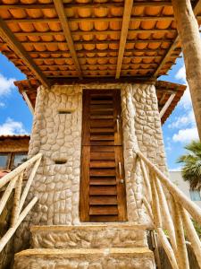 a stone building with a wooden door and stairs at Casa do Parcerito in Cajueiro