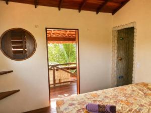 a bedroom with a bed and a door to a porch at Casa do Parcerito in Cajueiro