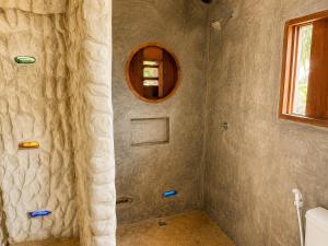 a bathroom with a shower with a mirror at Casa do Parcerito in Cajueiro