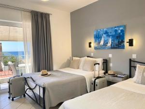 a hotel room with two beds and a balcony at Thalassa Kai almira studios in Sarti
