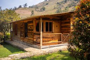 a log cabin with a mountain in the background at Hotel Campestre Rocas Del Paraíso in Machetá