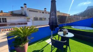 a balcony with a table and an umbrella and plants at Hotel Cal Tet in L'Estartit +27 photos