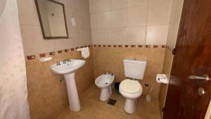 a bathroom with a toilet and a sink at Hotel y Cabañas Gran Cordoba in La Falda +29 photos