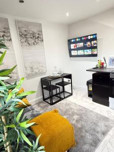 a living room with a yellow rug and a table at One Bedroom Luxurious Flat - Free Parking in Rochester