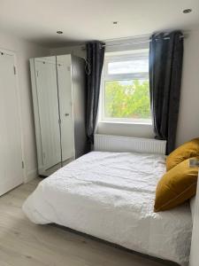 a bedroom with a white bed and a window at One Bedroom Luxurious Flat - Free Parking in Rochester