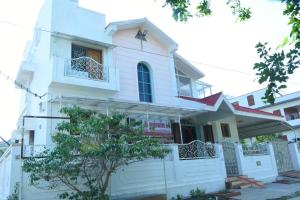 a white house with a gate and a balcony at jayaram Home Palace Chittoor in Chittoor