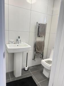 a white bathroom with a sink and a toilet at One Bedroom Luxurious Flat - Free Parking in Rochester