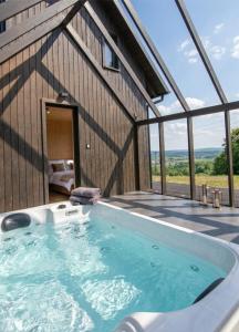 a hot tub on the deck of a house at Zimna Woda 50 Brenna in Brenna